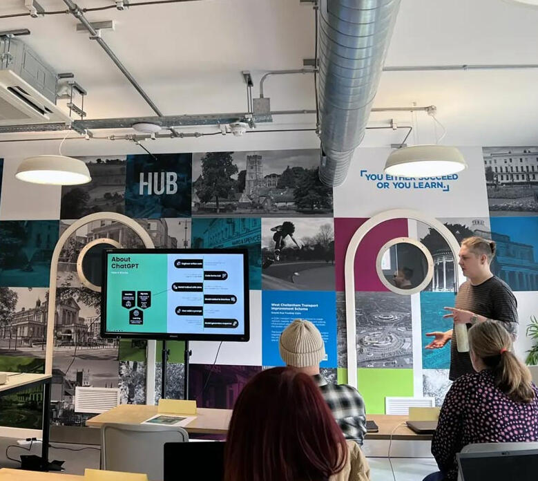 Iselle delivering a practical ChatGPT workshop at The Growth Hub Cheltenham with attendees watching a presentation screen